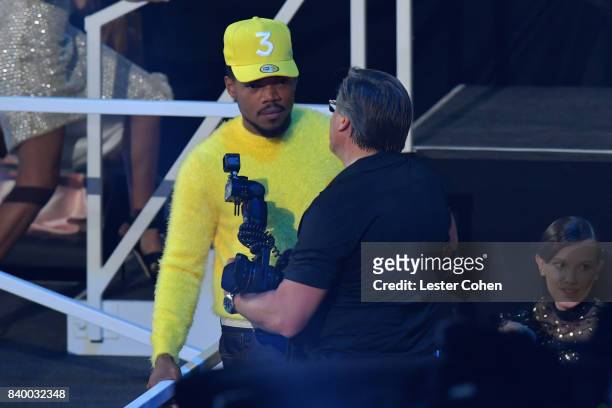 Chance the Rapper speaks to photographer Kevin Mazur near the stage during the 2017 MTV Video Music Awards at The Forum on August 27, 2017 in...
