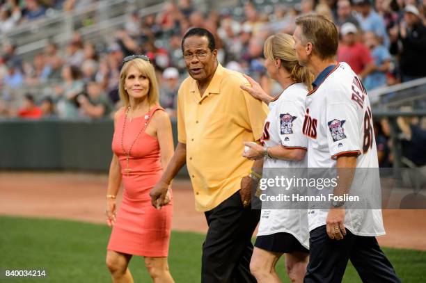 Hall of Fame player Rod Carew walks onto the field with his wife, Rhonda, and Mary and Ralf Reuland, parents of the late Konrad Reuland, before the...