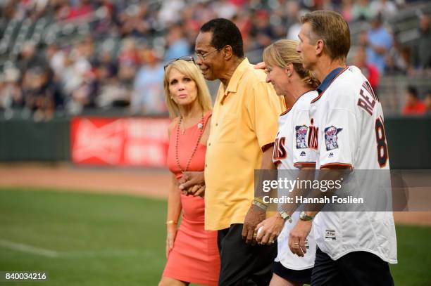 Hall of Fame player Rod Carew walks onto the field with his wife, Rhonda, and Mary and Ralf Reuland, parents of the late Konrad Reuland, before the...