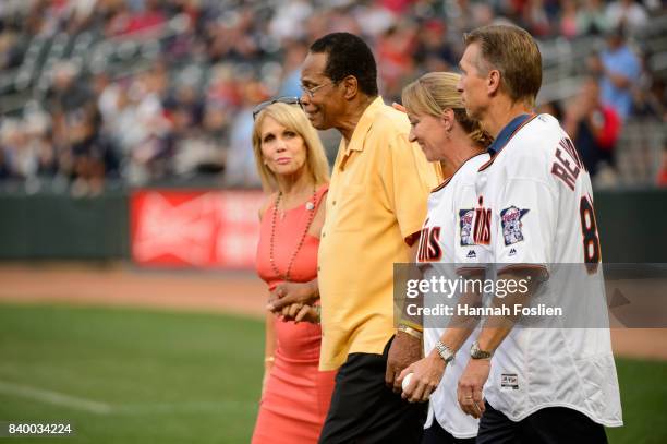 Hall of Fame player Rod Carew walks onto the field with his wife, Rhonda, and Mary and Ralf Reuland, parents of the late Konrad Reuland, before the...