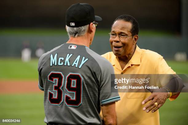 Hall of Fame player Rod Carew hugs first base coach Dave McKay of the Arizona Diamondbacks before the game against the Minnesota Twins on August 18,...