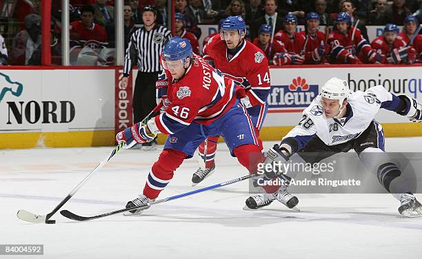 Zenon Konopka of the Tampa Bay Lightning reaches to defend against Andrei Kostitsyn of the Montreal Canadiens as he stickhandles the puck across the...