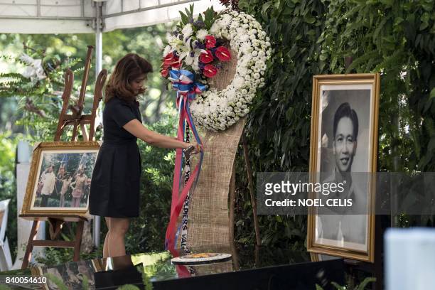 Imee Marcos, daughter of former Philippine president and late dictator Ferdinand Marcos, adjusts a wreath at the tomb her father on National Heroes'...