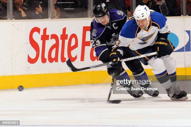 Mike Weaver of the St. Louis Blues battles for the puck against Dustin Brown of the Los Angeles Kings during the game on December 11, 2008 at Staples...