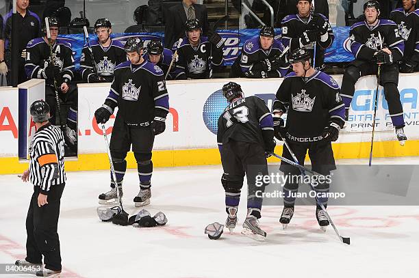 The Los Angeles Kings help pick up hats from the ice thrown by fans in celebration of Dustin Brown's first career hat trick during the game against...