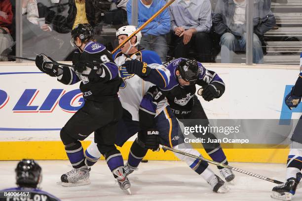 Eric Brewer of the St. Louis Blues gets tangled up against Oscar Moller and Michal Handzus of the Los Angeles Kings during the game on December 11,...