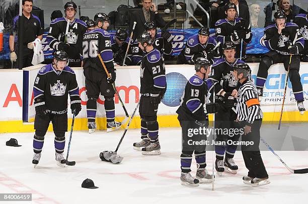 The Los Angeles Kings help pick up hats from the ice thrown by fans in celebration of Dustin Brown's first career hat trick during the game against...