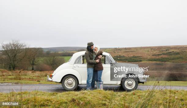 couple hugging outside old car - gorro-de-lã imagens e fotografias de stock