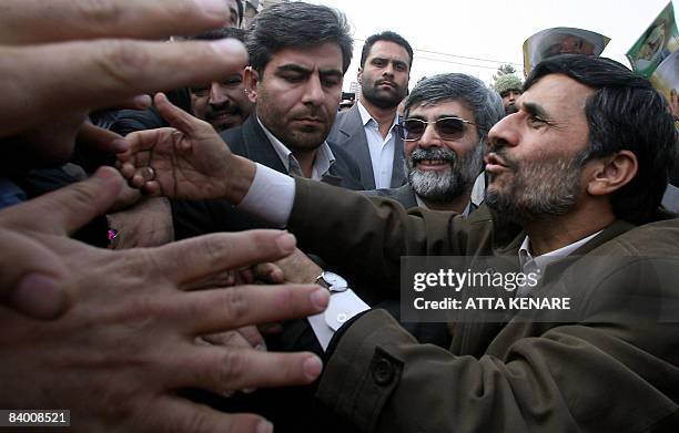 Iranian President Mahmoud Ahmadinejad shakes hands with demonstrators during a protest in support of the Israeli-blockaded Gaza Strip in Tehran on...