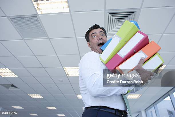 businessman carrying several files in an office - middelgrote groep dingen stockfoto's en -beelden