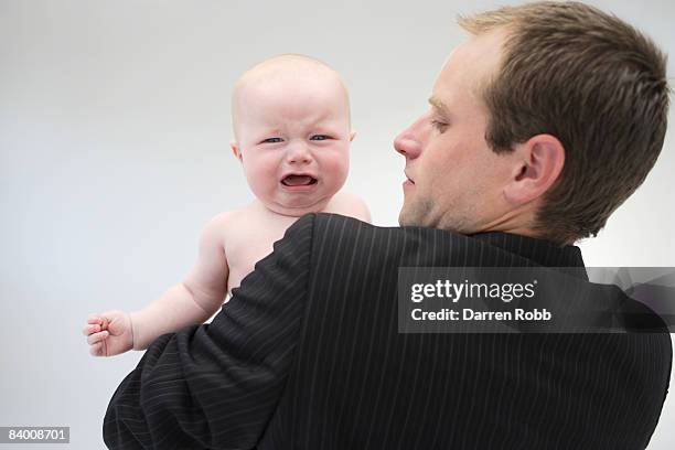 businessman holding a crying baby boy - man cry touching stock pictures, royalty-free photos & images