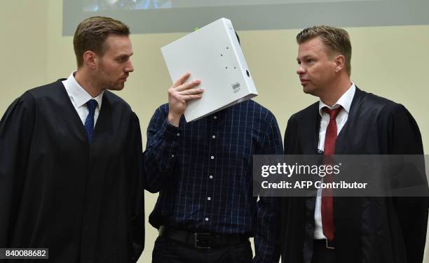 The defendant Philipp K. And his lawyers David Muehlberger and Sascha Marks speak together in a court room at the country court in Munich, southern...