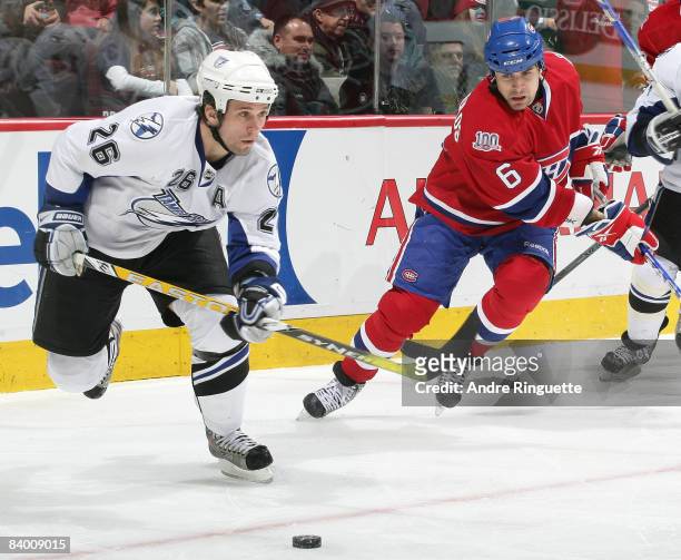Martin St. Louis of the Tampa Bay Lightning stickhandles the puck against Tom Kostopoulos of the Montreal Canadiens at the Bell Centre December 11,...