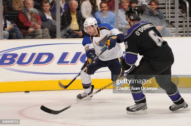 Brad Boyes of the St. Louis Blues passes the puck as Sean O'Donnell of the Los Angeles Kings defends on December 11, 2008 at Staples Center in Los...