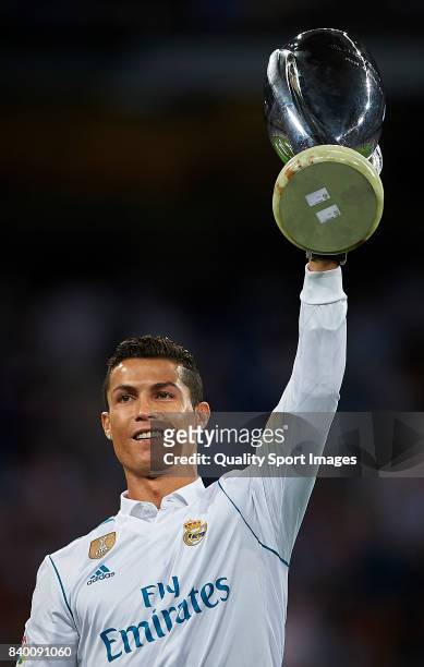Cristiano Ronaldo of Real Madrid holds up the UEFA Super Cup trophy prior to the La Liga match between Real Madrid and Valencia at Estadio Santiago...
