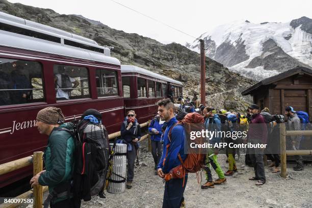 Mountaineers wait to board the Mont Blanc Tramway at the highest station "Le nid d'Aigle" on August 27, 2017 on the Mont-Blanc range near...