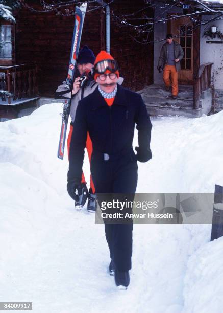 Prince Charles, Prince of Wales wears a joke mask to tease photographers by pretending to be someone named 'Uncle Harry' during a skiing holiday on...