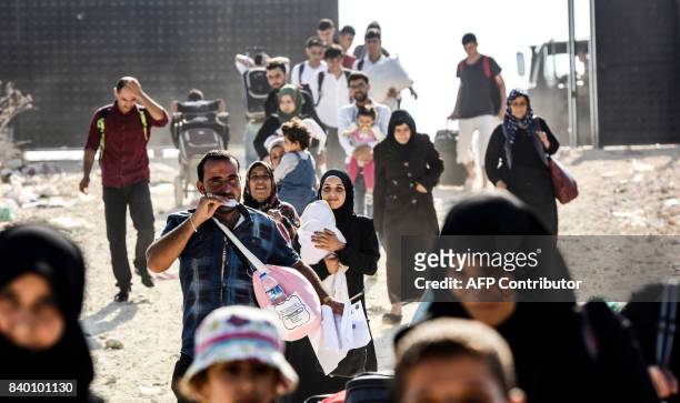 Syrian refugees arrive at the Oncupinar crossing gate, close to the town of Kilis, south central Turkey, in order to cross to Syria for the Eid...