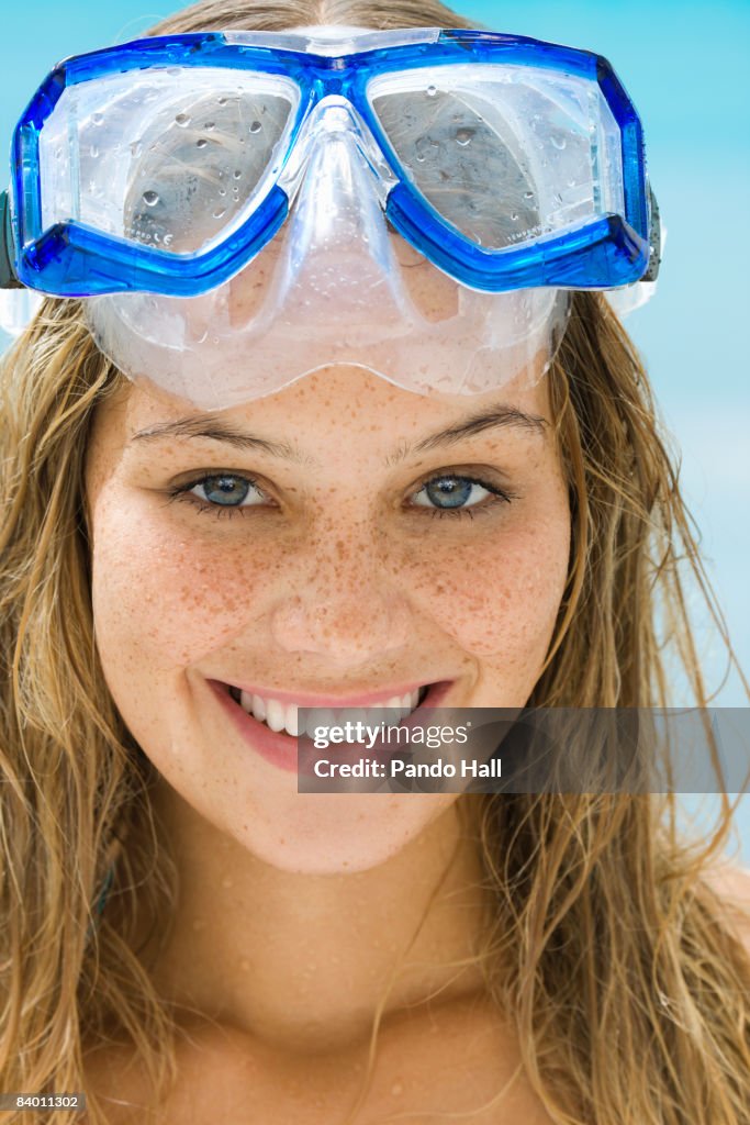 Young woman wearing goggles smiling, close-up 