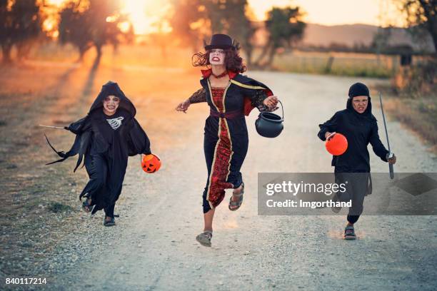 halloween kinder laufen auf feldweg - running fancy dress stock-fotos und bilder