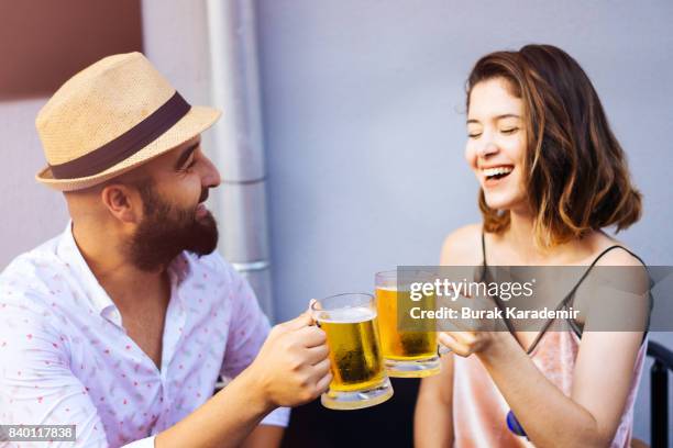 couple drinking beer at outdoor bar - biergarten stock-fotos und bilder