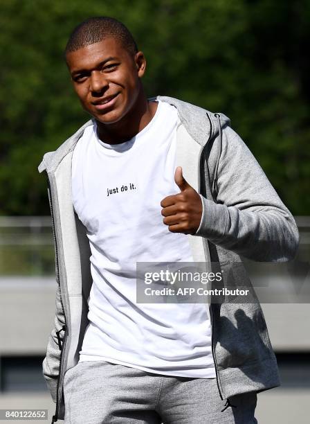 France's forward Kylian Mbappe gives a thumbs-up as he arrives at the French national football team training base in Clairefontaine on August 28 as...