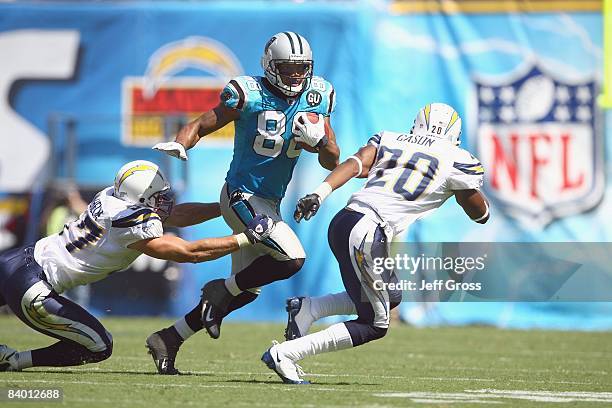 Dante Rosario of the Carolina Panthers carries the ball against Antoine Cason and Matt Wilhelm of the San Diego Chargers at Qualcomm Stadium on...