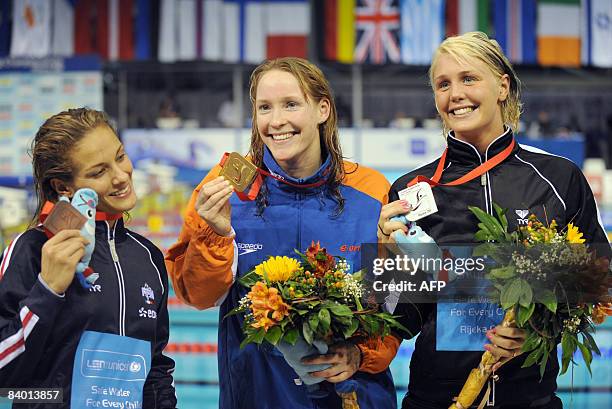 Hinkelien Schreuder of the Netherlands celebrates her gold medal after winning at women�s final 50m butterfly race, next to the second placed...