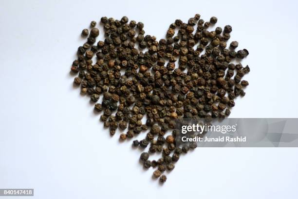 black pepper corn (piper nigrum) in heart shape - black pepper stock pictures, royalty-free photos & images