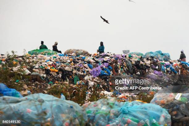 Women work at the Ngong town dumping site, 30 kilometres southwest of Nairobi, on August 24, 2017 A ban on plastic bags came into force in Kenya on...