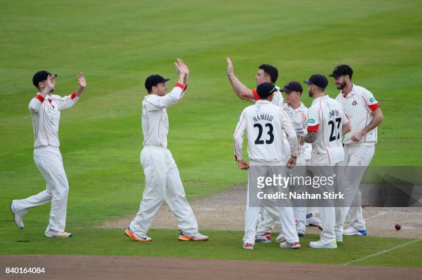 Jos Buttler high fives Ryan McLaren of Lancashire after he takes a wicket during the County Championship Division One match between Lancashire and...