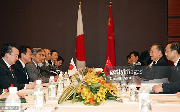 Japanese Prime Minister Taro Aso speaks with Chinese Premier Wen Jiabao during a bilateral meeting prior to the first Japan-China-South Korea...