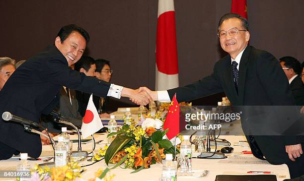 Japanese Prime Minister Taro Aso shakes hands with Chinese Premier Wen Jiabao during a bilateral meeting prior to the first Japan-China-South Korea...