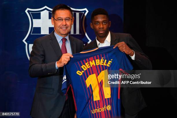 Barcelona's new player Ousmane Dembele poses with his new jersey next to Barcelona's president Josep Maria Bartomeu at the Camp Nou stadium in...
