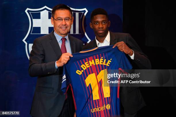 Barcelona's new player Ousmane Dembele poses with his new jersey next to Barcelona's president Josep Maria Bartomeu at the Camp Nou stadium in...