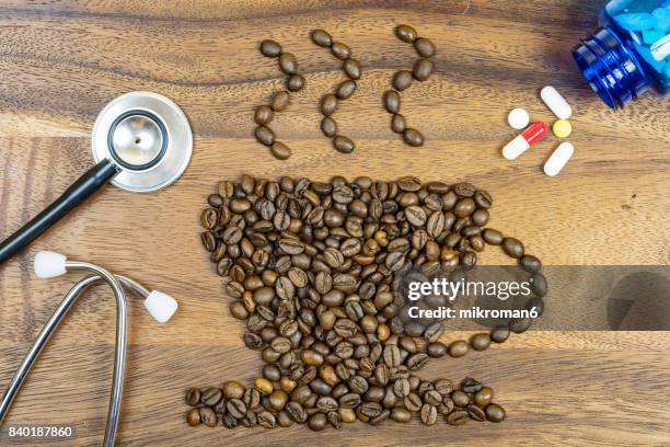 cup coffee made by roasted coffee beans and stethoscope.  medical concept - caffeine molecule stock pictures, royalty-free photos & images