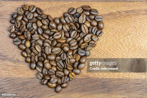 heart made by roasted coffee beans - coffee heart stock pictures, royalty-free photos & images