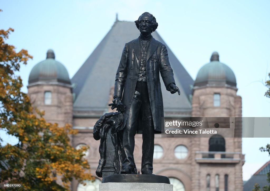 A statue of Sir John A Macdonald stands high in front of Queens Park