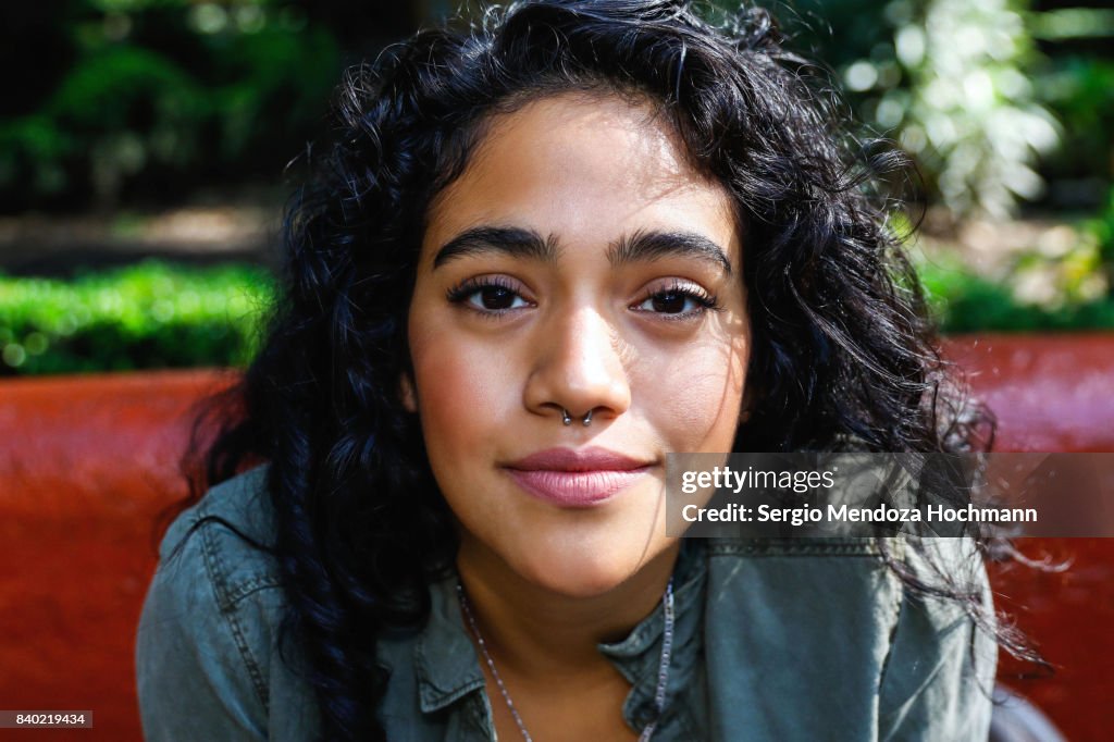 Portrait of one young Hispanic woman smiling and looking at camera in Mexico City