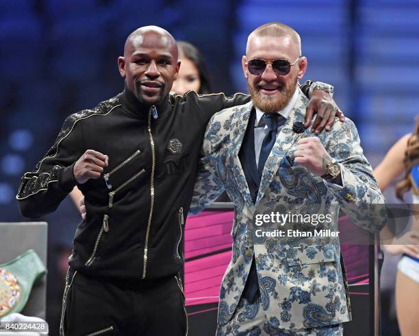 Floyd Mayweather Jr. And Conor McGregor pose for pictures during a news conference after Mayweather's 10th-round TKO victory in their super...