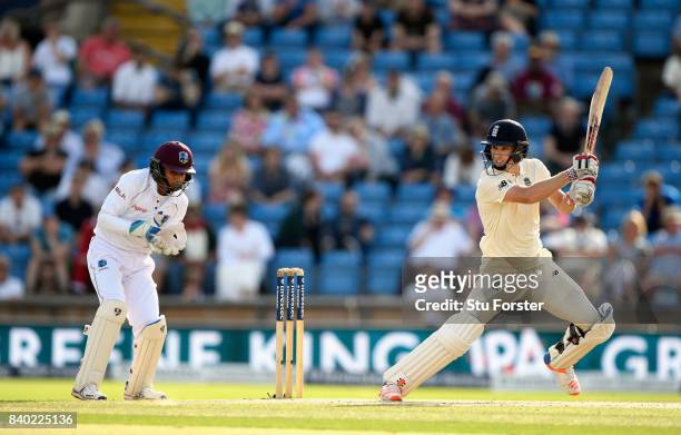 England batsman Chris Woakes cuts a ball towards the boundary watched by keeper Shane Dowrich during day four of the 2nd Investec Test Match between...