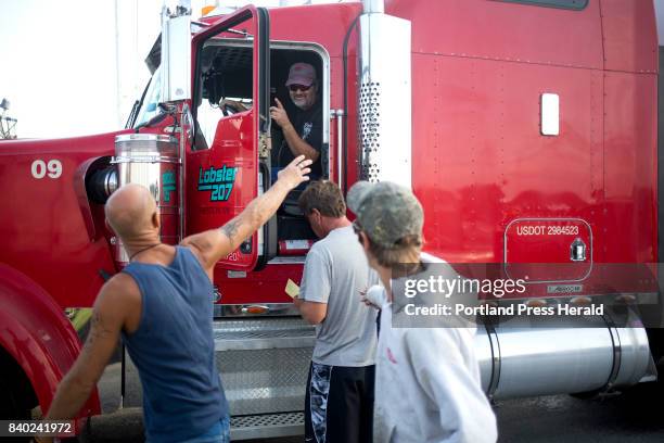 Dwayne Bradford, a union driver, waves goodbye to some of the Fox Island Lobstering crew after loading their union-caught lobster from Vinalhaven...