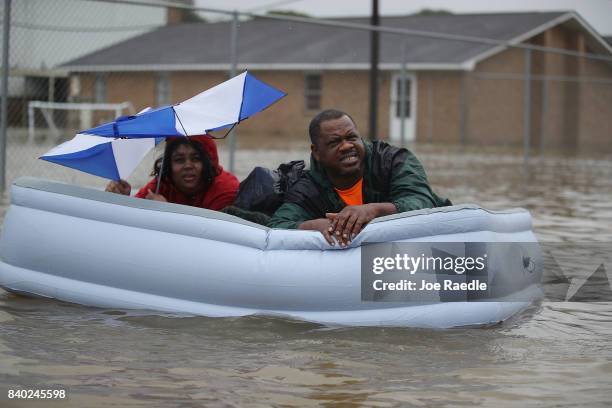 People use a inflatated mattress to evacuate their homes after the area was inundated with flooding from Hurricane Harvey on August 28, 2017 in...