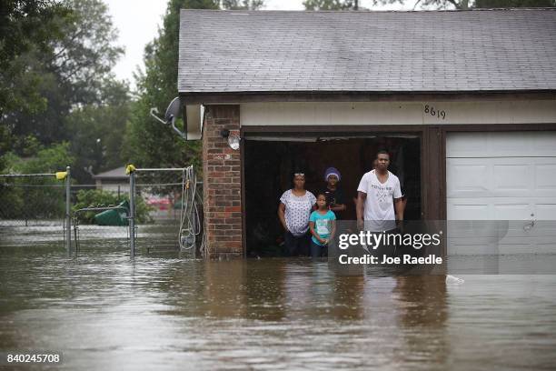 People wait to be rescued from their flooded homes after the area was inundated with flooding from Hurricane Harvey on August 28, 2017 in Houston,...