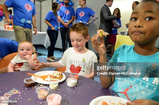 Carter, Brendan, and Daniel decorate donuts during Day of Joy Celebration at Boston Children's Hospital August 28, 2017 in Boston, Massachusetts.
