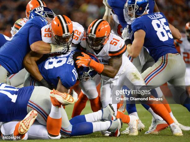 Defensive lineman Desmond Bryant and linebacker Jamie Collins Sr. #51 of the Cleveland Browns tackle running back Paul Perkins of the New York Giants...