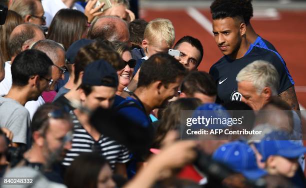 France's midfielder Corentin Tolisso poses with fans during a training session in Clairefontaine en Yvelines on August 28 as part of the team's...