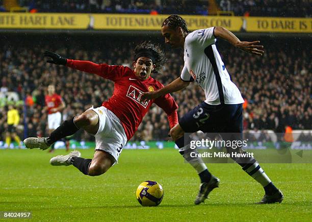 Benoit Assou-Ekotto of Tottenham Hotspur is challenged by Carlos Tevez of Manchester United during the Barclays Premier League match between...