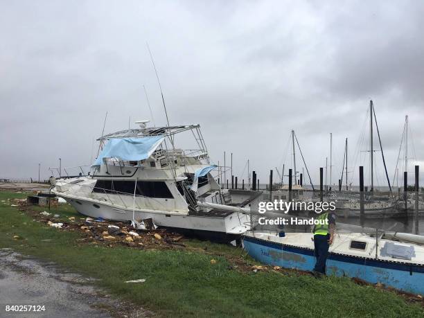 In this handout provided by the U.S. Coast Guard, Coast Guard National Strike Force members assess port damage and survey for potential pollution and...