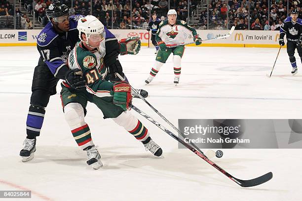 Marc-Andre Bergeron of the Minnesota Wild battles for the puck against Wayne Simmonds of the Los Angeles Kings on December 13, 2008 at Staples Center...
